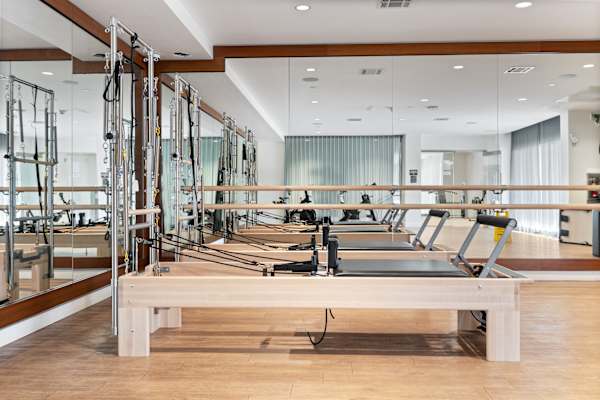 a row of weights machines in a room with mirrors
